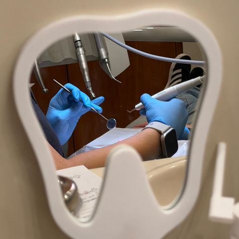 Instrumental de odontología reflejado en un espejo con forma de muela